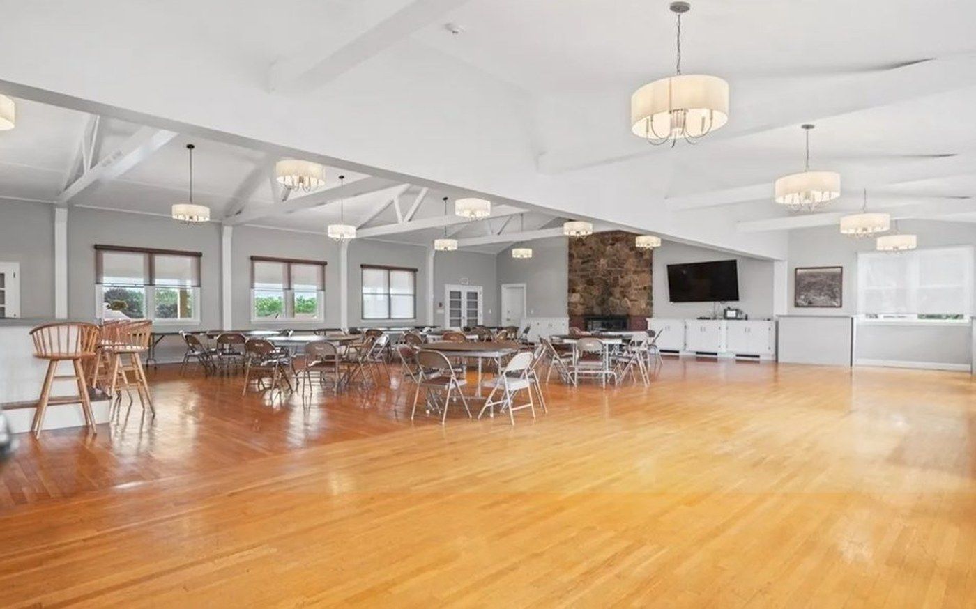 The Royal Crest Function Hall with vaulted ceiling, stone fireplace, and pendant lighting